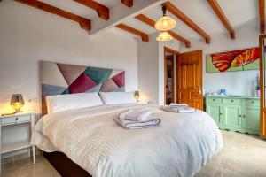 a bedroom with a large bed with towels on it at Casa las Torres B&B in Iznate