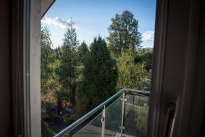 a window with a view of trees from a balcony at Motelik Julia in Siedlce +18 photos