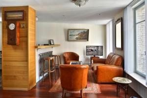 a waiting room with leather chairs and a fireplace at Appartement Mogador in Honfleur