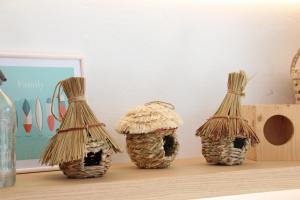 three straw covered containers sitting on a table at Aparthotel Niu d´Aus in Portopetro