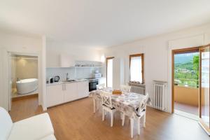 a kitchen and dining room with a table and chairs at Dolomiti Suite in Belluno