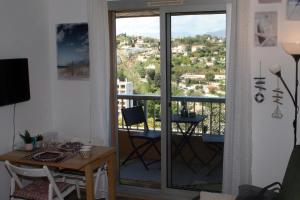 ein Wohnzimmer mit einem Balkon mit einem Tisch und Aussicht in der Unterkunft Studio Le Fabrina Riviera in Nizza