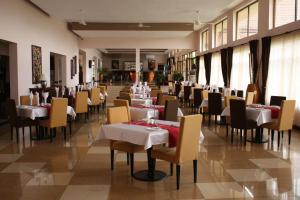 a dining room with tables and chairs in a restaurant at Nashera Hotel in Morogoro