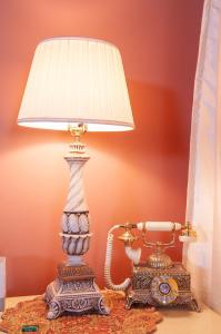 una lámpara sentada en una mesa junto a un teléfono en The Historic Wolf Hotel, en Ellinwood