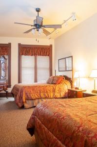 a bedroom with two beds and a ceiling fan at The Historic Wolf Hotel in Ellinwood