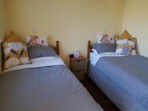 2 Betten nebeneinander in einem Zimmer in der Unterkunft Cross Swords Rooms, Skillington in Skillington