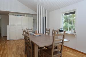Villa near Åhus في Yngsjö: غرفة طعام مع طاولة وكراسي خشبية