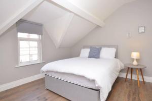 a white bedroom with a bed and a window at Queens Quarter Townhouse 2 in Belfast