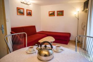 a tea kettle on a table with a couch at Apartments and Rooms Villa Vive in Bled