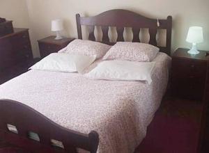 um quarto com uma cama grande com lençóis brancos e almofadas em Praia da Torreira à Vista em Torreira