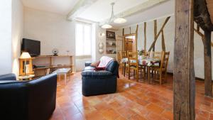 a living room with a couch and a dining room at Le Guitou in Monlezun