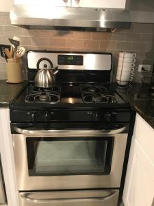 a kitchen with a stove with a tea kettle on it at webster house in Chicago