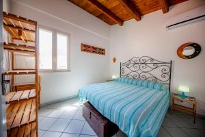 a bedroom with a bed in a room with a window at Il terrazzino Holiday Home in Cefalù