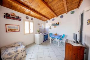 a room with a bed and a table with a television at Il terrazzino Holiday Home in Cefalù