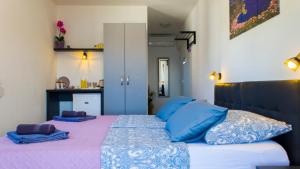 a bedroom with a large bed with blue pillows at A lovely and cozy room with a breathtaking view in Vis