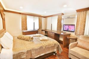 a bedroom with a bed and a desk and a television at Kumluk Konak Hotel in Istanbul
