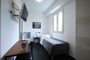 a bedroom with a bed and a desk and a tv at Sunrise B&B Sicilia Avola in Avola
