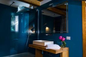 een blauwe badkamer met een wastafel en een spiegel bij Villa Di Natale in Pagani