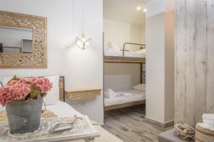 a room with a bed and a mirror and a table with flowers at Meltemi luxury apartments in Nea Roda