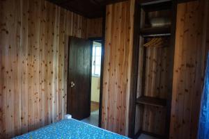 a bedroom with wooden walls and a bed in a room at Portugal House in Praia do Norte