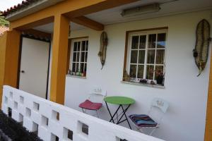 a porch of a house with a green table and chairs at Portugal House in Praia do Norte +18 photos