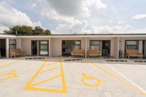 a building with benches in a parking lot at Pukekohe Motel in Pukekohe East