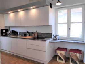a kitchen with white cabinets and a counter top at Clos des Arts Suspendus in Avignon