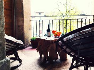 - une table avec une bouteille de vin et des fruits sur un balcon dans l'établissement Clos des Arts Suspendus, à Avignon