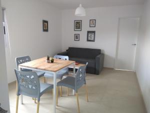 ein Wohnzimmer mit einem Tisch, Stühlen und einem Sofa in der Unterkunft COZY II DEPARTAMENTO EN PLENO CENTRO DE MENDOZA in Mendoza