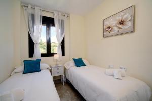 two white beds in a room with a window at Apartamento Costa Galera DUPLEX PENTHOUSE in Estepona +20 photos