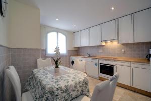 a kitchen with a table and white cabinets and a table and chairs at Apartamento Costa Galera DUPLEX PENTHOUSE in Estepona