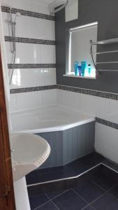 a bathroom with a bath tub and a sink at East Park House in Wolverhampton
