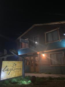 a building with a sign in front of it at night at Hostal Lejana Patagonia in Cochrane