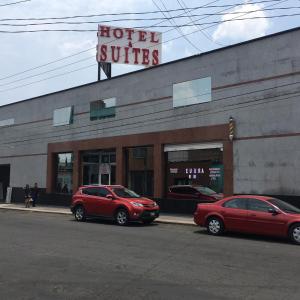 dos coches rojos estacionados frente a una suite de hotel en Hotel & suites elba en Toluca