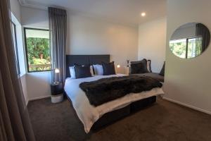 a bedroom with a large bed and a mirror at Lakeview Lodge Karapiro in Cambridge
