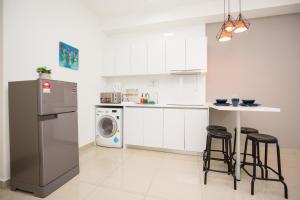 a kitchen with a refrigerator and a washing machine at Arte Plus KLCC by PSM Luxury Suites in Kuala Lumpur