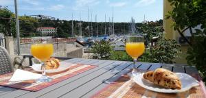two glasses of orange juice and pastries on a table at Apartment Sea princess in Vrboska