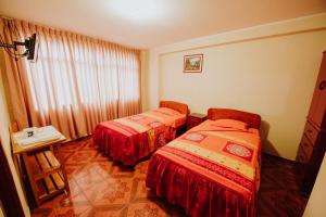 a room with two beds and a window at Hotel Las Viñas in Huánuco