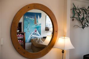 a mirror on a wall next to a lamp at Boathouse - Birks River Retreat in Goolwa