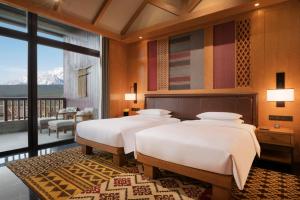 Voodi või voodid majutusasutuse Jinmao Purelax Mountain Hotel Lijiang toas