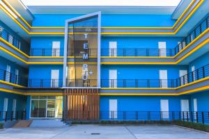 an exterior view of a blue building with balconies at Tempo Plus Apartment in Mae Sot