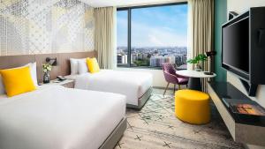 um quarto de hotel com duas camas e uma grande janela em Avani Sukhumvit Bangkok Hotel em Banguecoque