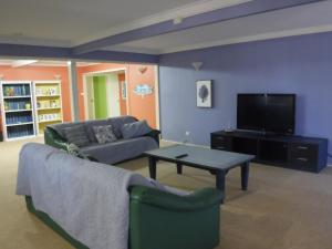 a living room filled with furniture and a tv at Meekatharra Outback Beach House in Meekatharra