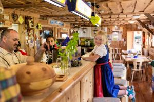 a little girl standing at a bar in a restaurant at Hiasl Zirbenhütte in Hochrindl