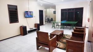 a living room with a ping pong table and chairs at Villa Cemara in Batu