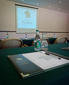 a book on a table with a bottle on it at Fitzgeralds Woodlands House Hotel in Adare +33 photos