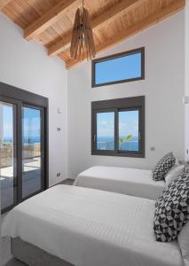 a bedroom with two beds and a window at Kathisma Bay Villas - Luxury Villas- Villa Oceanos in Kalamitsi