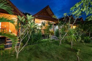 una casa con un jardín delante de ella en Dream Beach Inn, en Nusa Lembongan