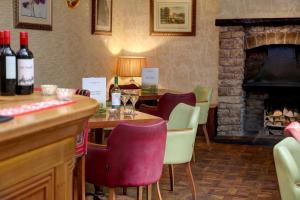 a bar with a table with wine glasses and a fireplace at The George Hotel in Penrith +67 photos