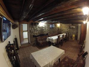 um quarto com uma mesa e cadeiras e uma parede de pedra em Къща за гости с минерална вода "Терма Асклепий" em Kyustendil